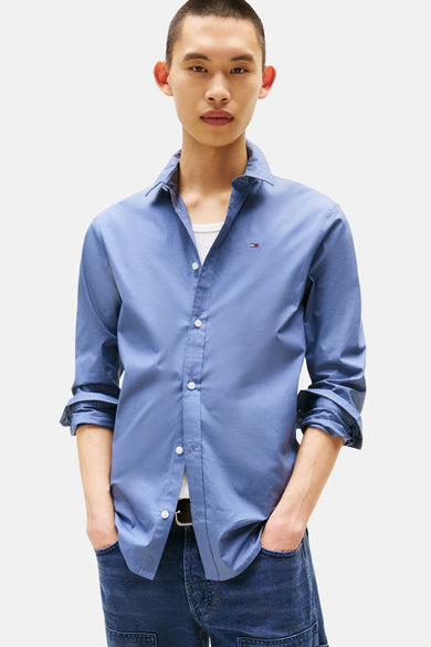 Blauw overhemd met lange mouwen van TOMMY JEANS, gedragen met een wit hemd en donkere jeans.