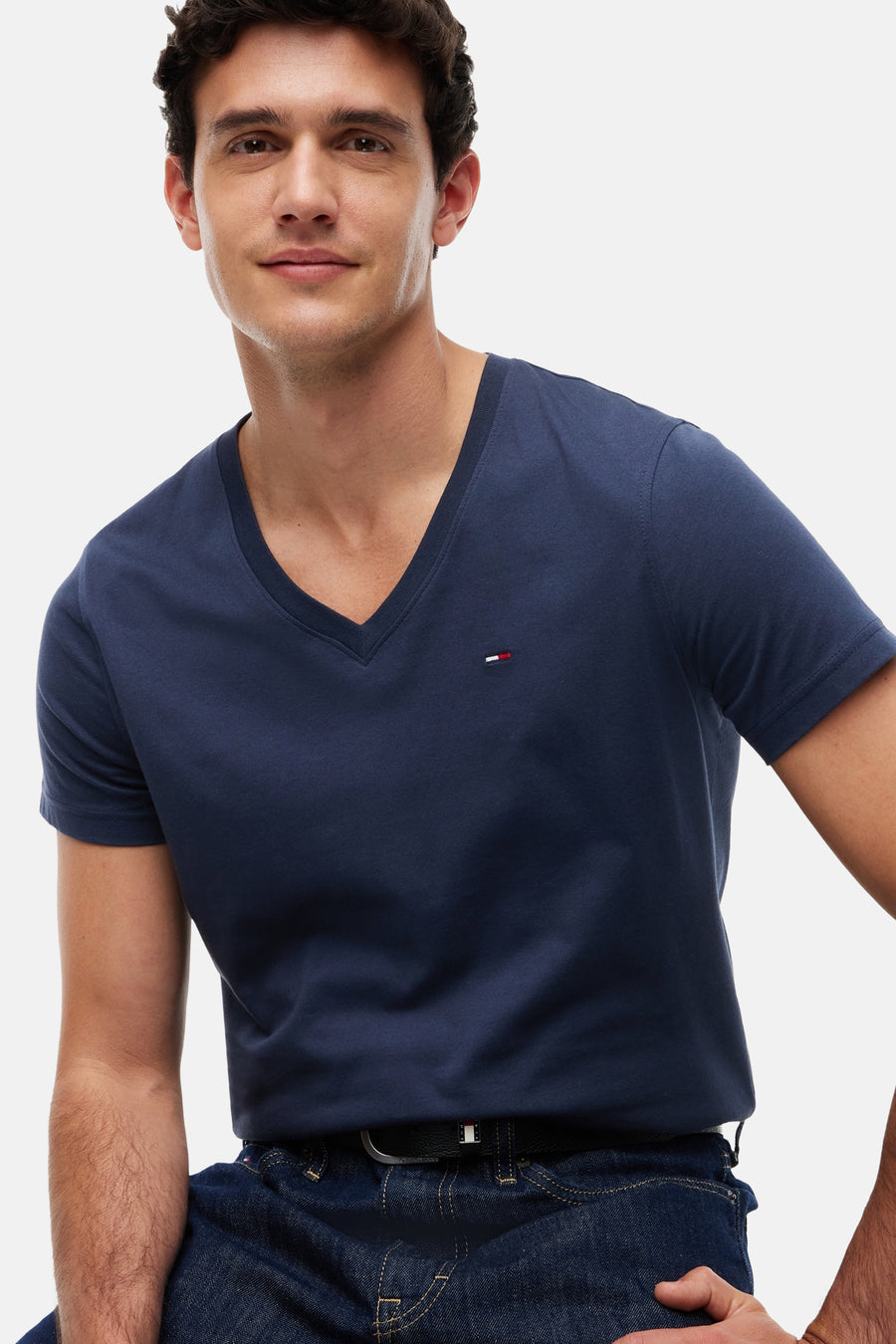 Blauwe V-hals T-shirt van TOMMY JEANS, met klein logo op borst, gedragen door model in lifestyle shot