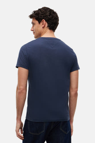 Blauwe korte mouw T-shirt van TOMMY JEANS, achterzijde, gladde stof, model in donkerblauwe jeans