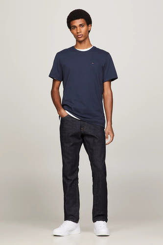 Blauw T-shirt van TOMMY JEANS, gedragen met donkere jeans en witte sneakers.