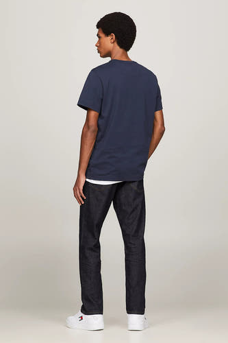 Blauw T-shirt van TOMMY JEANS, achterkantweergave, gecombineerd met donkere jeans en witte sneakers.