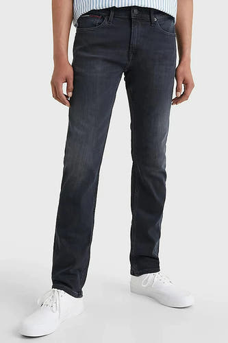 Donkergrijze slim fit jeans van TOMMY JEANS, met een subtiele wassing en witte sneakers.
