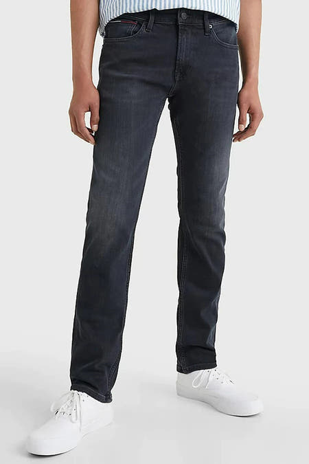 Donkergrijze slim fit jeans van TOMMY JEANS, met een subtiele wassing en witte sneakers.
