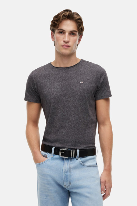 Zwart T-shirt van TOMMY JEANS, met korte mouwen, gedragen met een zwarte riem en lichte jeans.