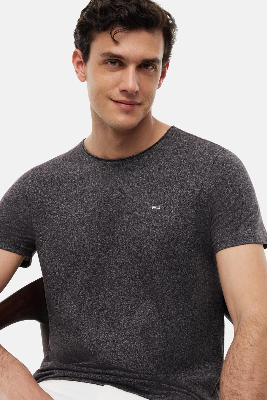 Zwart marl T-shirt met ronde hals van TOMMY JEANS, voorzien van klein logo op borst, gedragen door man in lifestyle shot