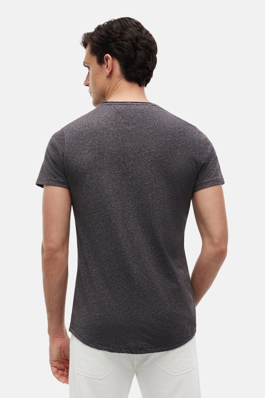 Zwart marl T-shirt van TOMMY JEANS, rugzijde, korte mouwen, ronde hals, lichte textuur, model in witte broek