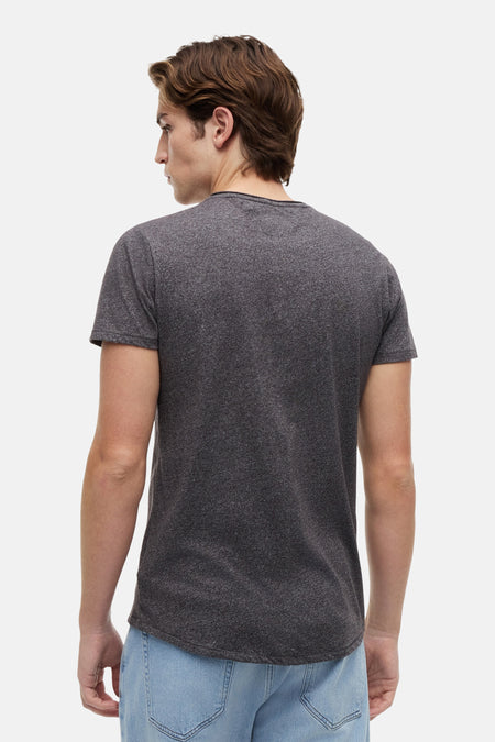 Zwart T-shirt van TOMMY JEANS, achterkant gezien, met korte mouwen en casual pasvorm, gedragen met blauwe jeans.