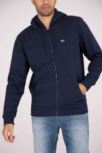 Pull-over bleu avec fermeture éclair de TOMMY JEANS, avec capuche et poches, associé à un jean bleu.