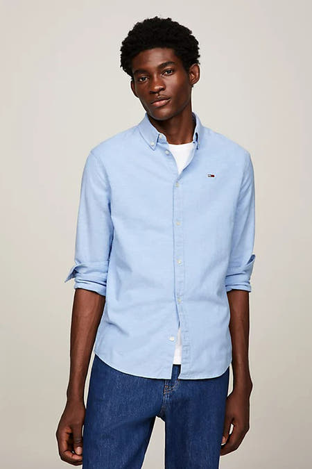 Blauw overhemd met lange mouwen van TOMMY JEANS, gedragen met een wit T-shirt en donkere jeans.