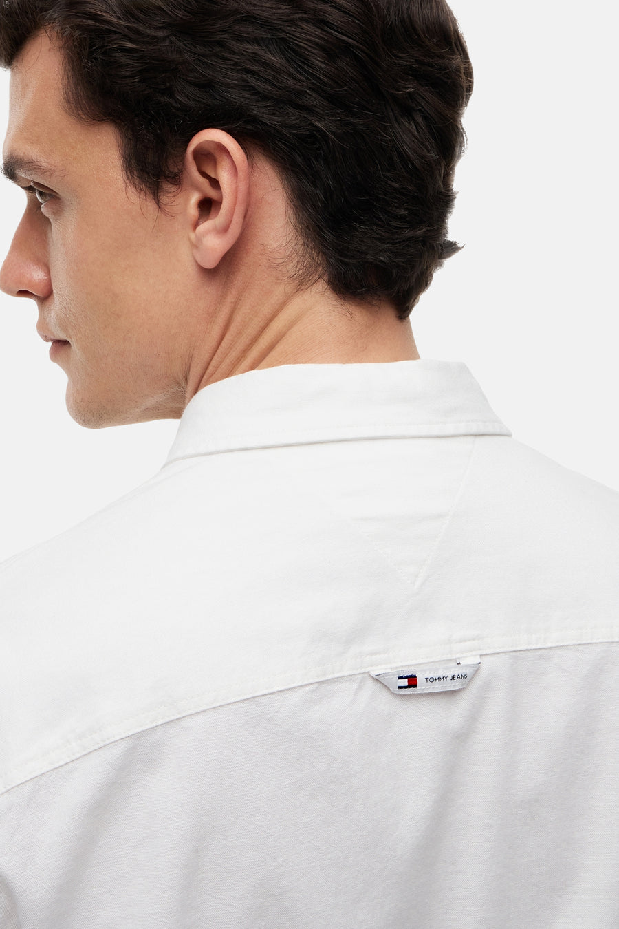 Wit hemd met lange mouwen van TOMMY JEANS, van achteren gezien met klein merklabel op de rug.