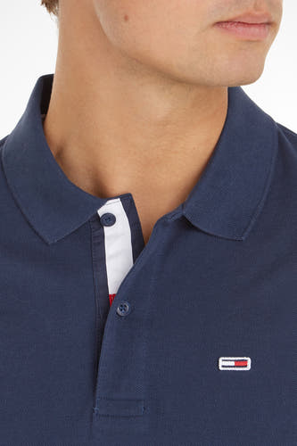 Polo bleu de TOMMY JEANS avec des manches courtes et un détail du nom de la marque sur la poitrine.