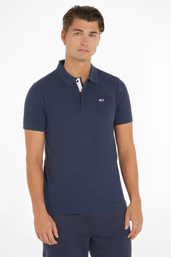 Polo bleu de TOMMY JEANS, avec des manches courtes et un petit logo brodé sur la poitrine.