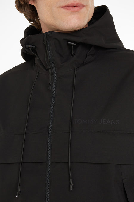 Zwarte korte jas met capuchon van TOMMY JEANS, voorzien van rits en trekkoorden, close-up vooraanzicht