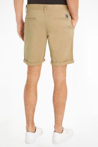 Achterkant van een man in kaki shorts met witte sneakers.