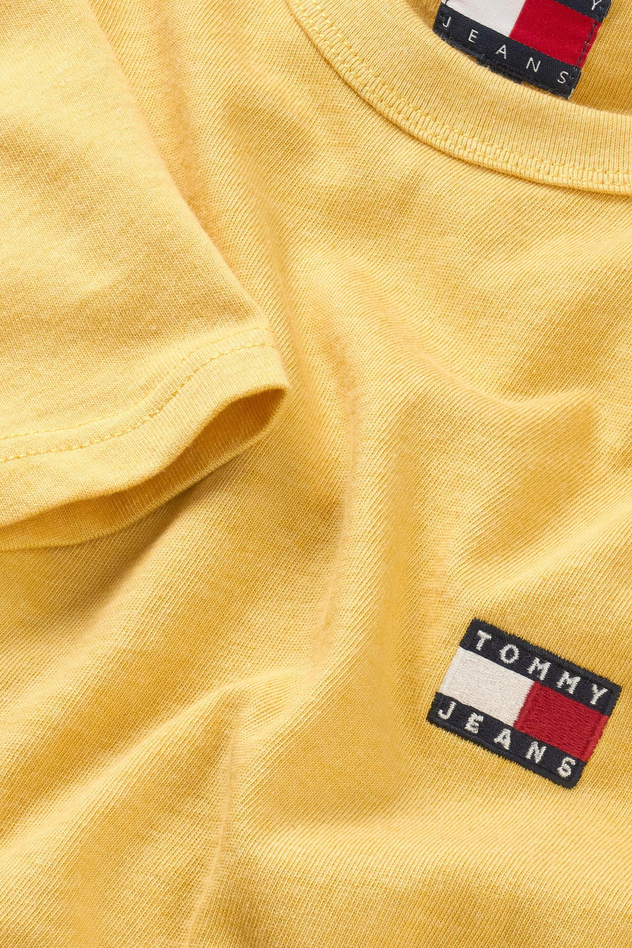 T-shirt jaune à manches courtes de Tommy Jeans, avec un patch logo sur la poitrine.