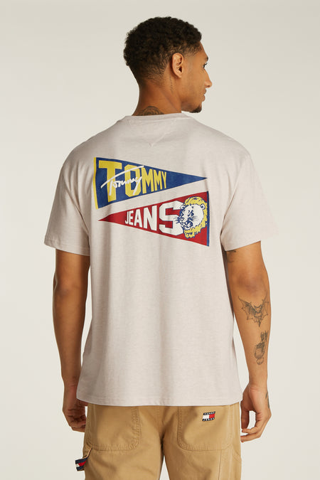 T-shirt écru à manches courtes de TOMMY JEANS, avec une impression graphique sur le dos et un pantalon kaki.