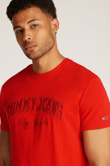 T-shirt rouge à manches courtes de TOMMY JEANS, avec des lettres brodées sur l'avant.