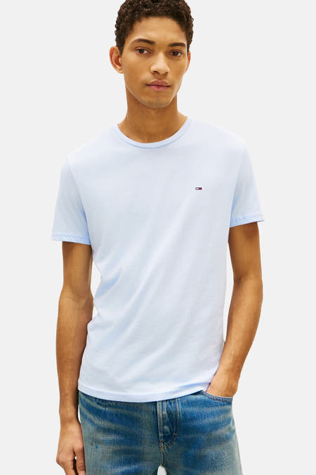Blauw T-shirt van TOMMY JEANS, met korte mouwen en een kleine logo-detail op de borst, gedragen met blauwe jeans.