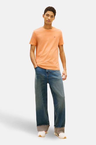 Oranje T-shirt met korte mouwen van Tommy Jeans, met een klein logo op de borst.
