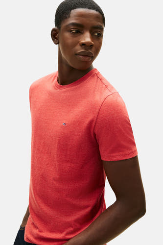 Rood T-shirt met korte mouwen van TOMMY JEANS, effen design met klein logo op de borst, gedragen door een model.