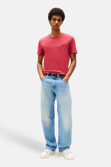 Rood T-shirt met korte mouwen van TOMMY JEANS, met losse jeans en witte sneakers.
