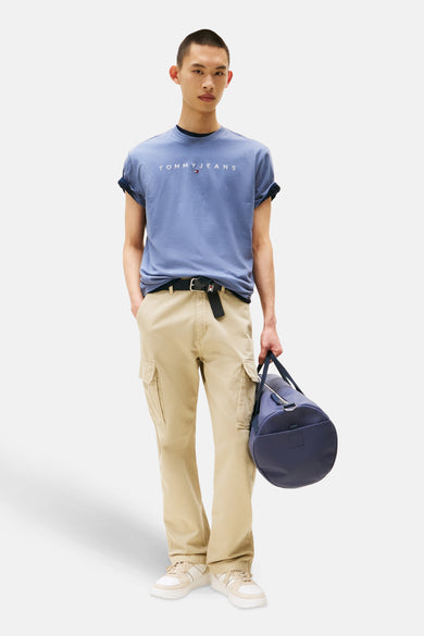 Blauw T-shirt met korte mouwen van TOMMY JEANS, met opgerolde mouwen, gedragen met kaki broek, riem en marineblauwe tas.