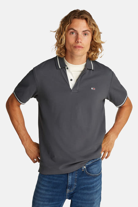 Grijs poloshirt met korte mouwen van Tommy Jeans, met witte bies langs de kraag en mouwen.