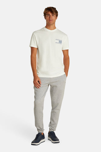 Man in wit t-shirt en grijze joggingbroek.