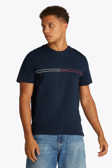 T-shirt bleu à manches courtes de TOMMY JEANS, avec des rayures horizontales et porté avec un jeans bleu.