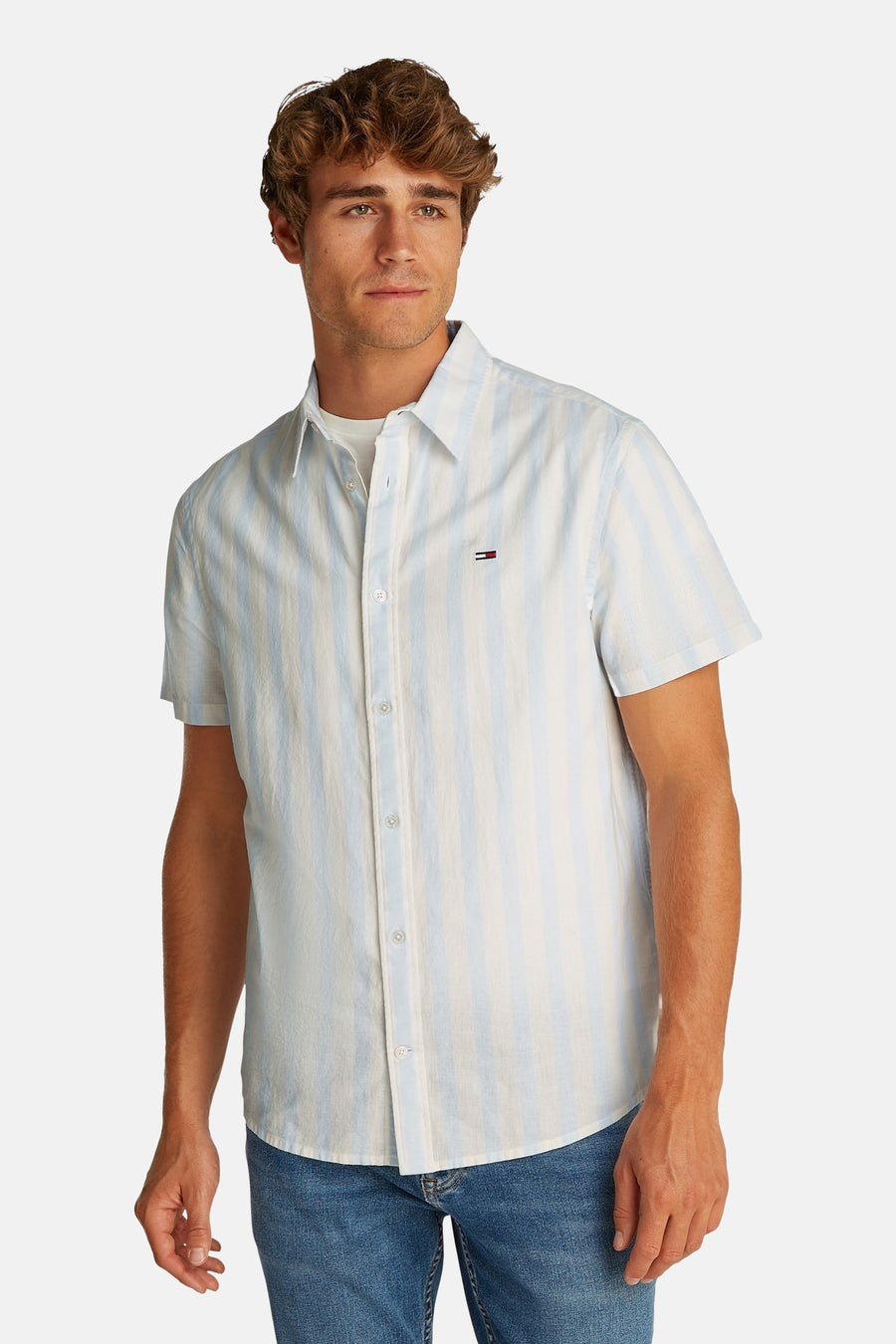 Blauw gestreept overhemd met korte mouwen van TOMMY JEANS, met knoopsluiting en een embleem op de borst.
