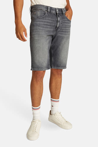 Shorts de jeans noirs de TOMMY JEANS, avec des chaussettes blanches et des baskets crème.