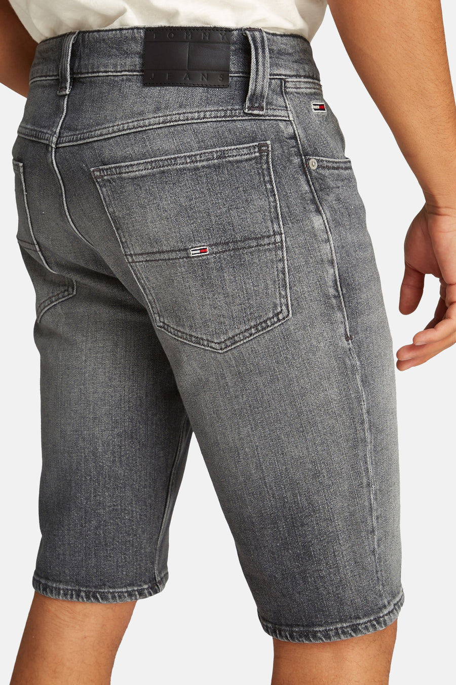 Jean court en denim noir de TOMMY JEANS, avec étiquette et détail de poche sur l'arrière.