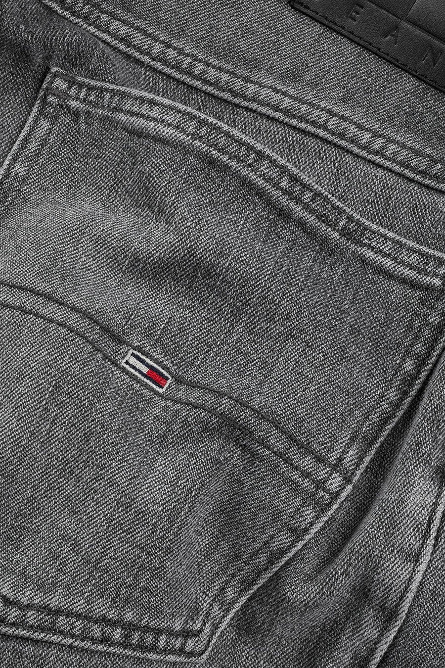 Jean court en denim noir de TOMMY JEANS, gros plan du poche arrière avec détail de logo.