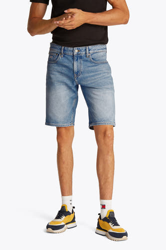 Jeansshort in lichtblauw denim van TOMMY JEANS, met witte sokken en kleurrijke sneakers.
