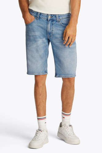 Jeansshort van lichtblauw denim van TOMMY JEANS, gedragen met witte sokken en sneakers.