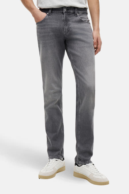 Slim-fit jeans van donkergrijs denim van TOMMY JEANS, met een subtiele wassing en witte sneakers.

