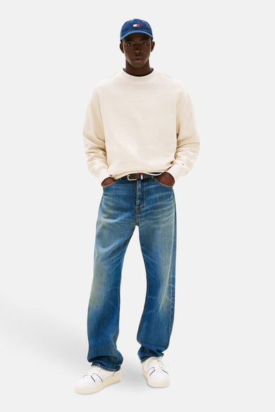 Beige sweater van TOMMY JEANS, met een subtiele wafeltextuur en gedragen met wijde jeans en witte sneakers.

