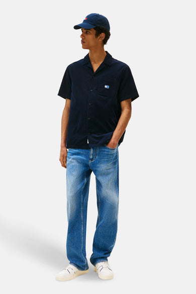Blau, shortsleeve shirt from TOMMY JEANS, with a button-up and worn with blue jeans and white sneakers.