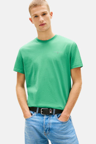 Groen T-shirt met korte mouwen van TOMMY JEANS, met een subtiel logo op de borst, gedragen met een jeans en riem.
