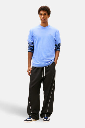 Blauw T-shirt van TOMMY JEANS, met korte mouwen en gecombineerd met een gestreept shirt met lange mouwen.