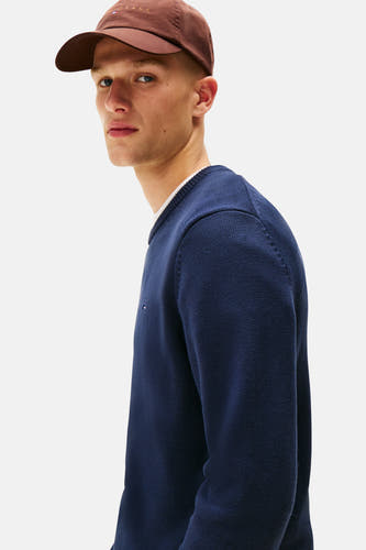 T-shirt bleu avec col rond de TOMMY JEANS, texture fine et large, porté avec un chapeau marron.