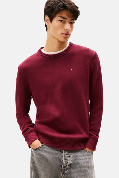 Bordeaux trui met ronde hals van TOMMY JEANS, met een klein logo op de borst en casual jeans.
