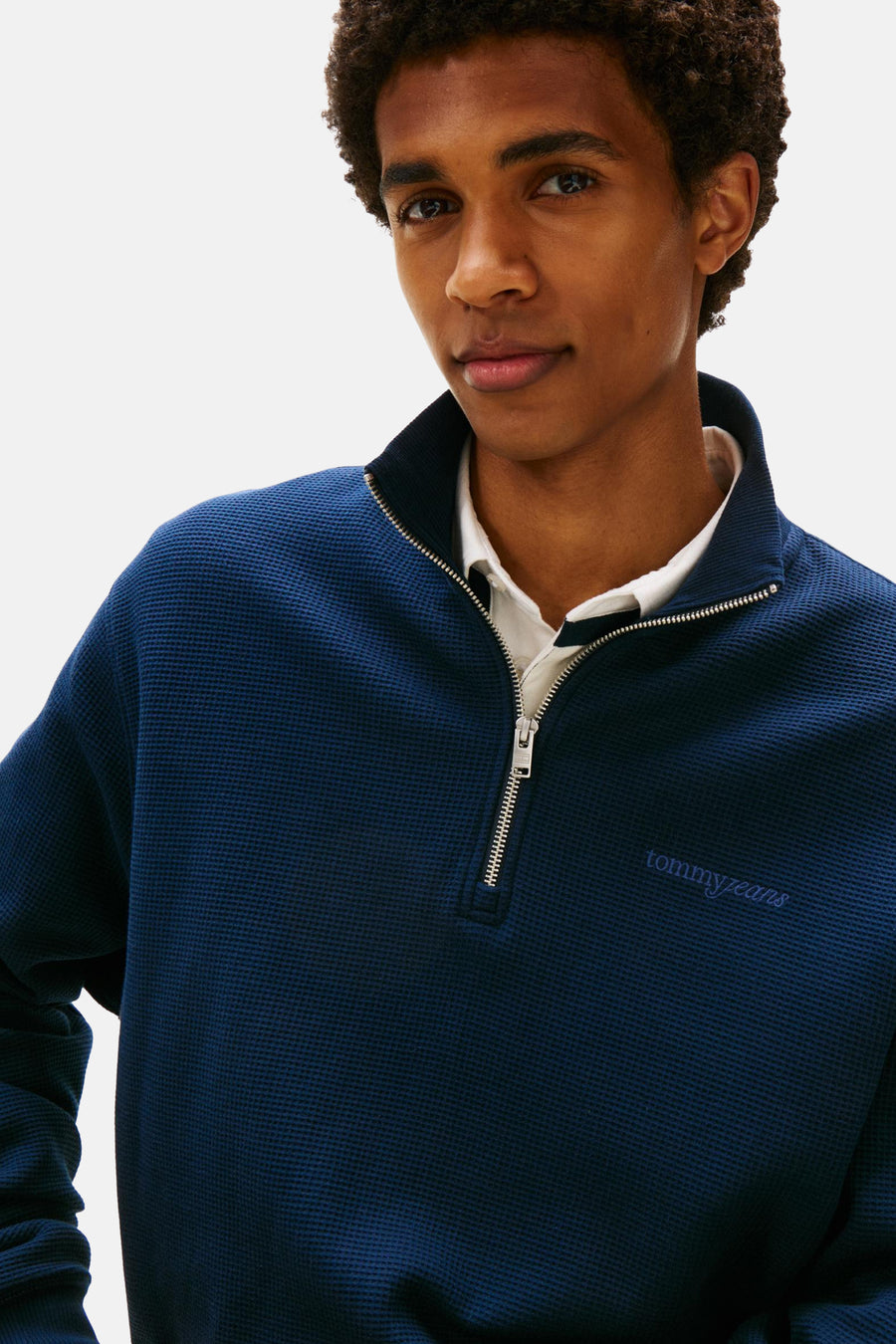 Blauwe sweater van TOMMY JEANS, met een halve rits en een wafeltextuur.