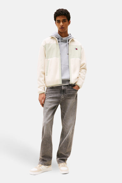 Beige jas van TOMMY JEANS met grijze hoodie en grijze jeans.