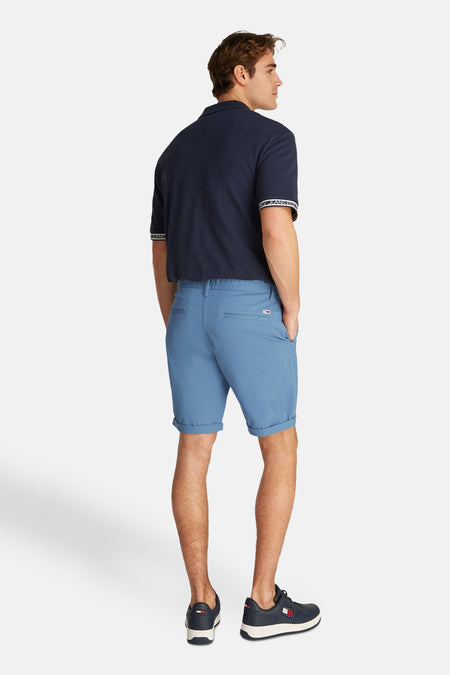 Short bleu de TOMMY JEANS, avec une enche relevée et un poche arrière, vu de derrière.