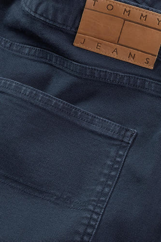 Jean court bleu de Tommy Jeans, avec logo de marque sur une étiquette en cuir.
