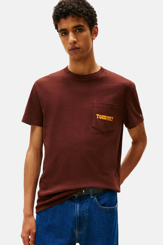 Bruin T-shirt met korte mouwen van TOMMY JEANS, met een borstzakje met logo en gecombineerd met een jeans.
