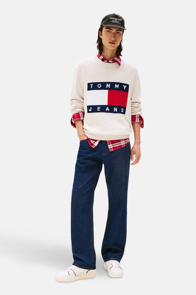 Ecru ronde hals trui van TOMMY JEANS, met rood geruite blouse, donkerblauwe jeans en witte sneakers.