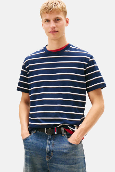 Blauw gestreept T-shirt met korte mouwen van TOMMY JEANS, gedragen met jeans en een riem.