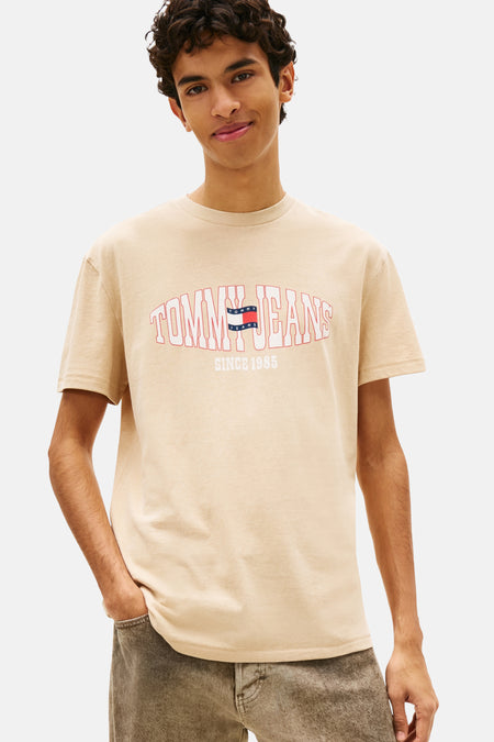 T-shirt beige de TOMMY JEANS avec logo bordé de rouge et inscription sur la poitrine.